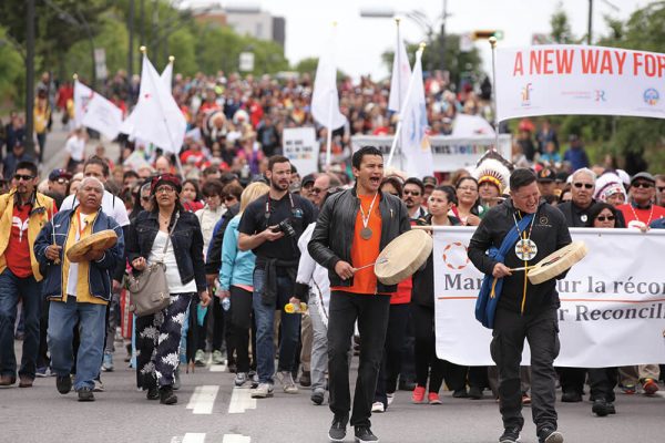 Peaceful protestors walking with signs and drums