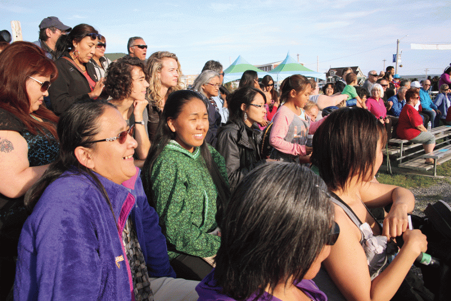 Group of people smiling and chatting, looking off into the distance