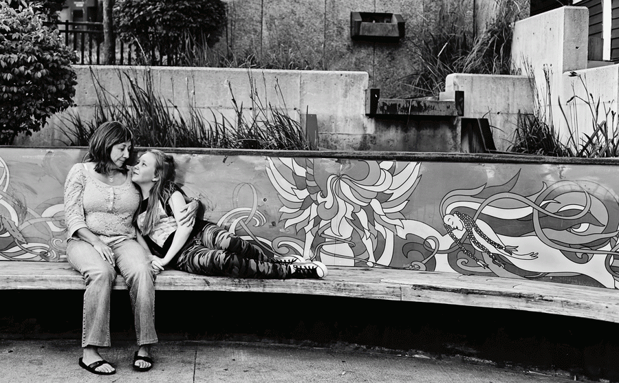 Suzanne (left) and Anna Ford in St. John’s on a bench featuring Inuit artwork.