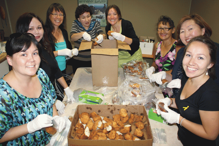 A group of 8 women preparing food