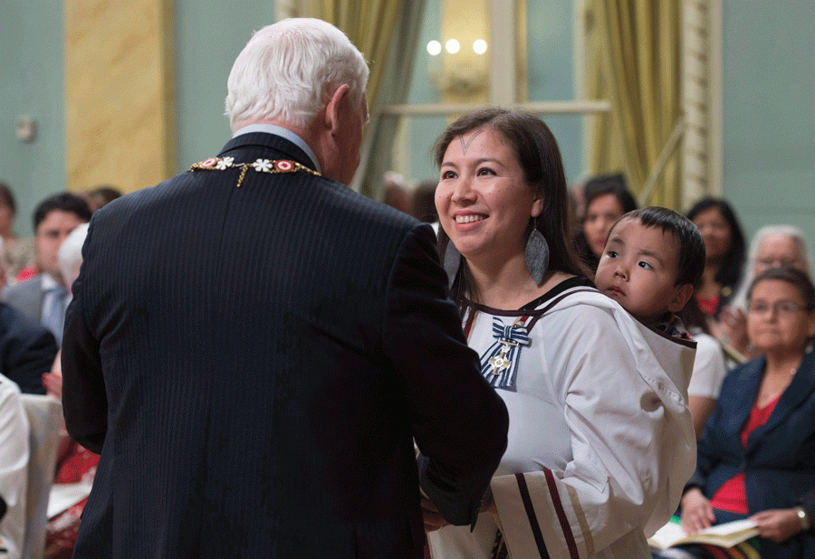 A woman smiles as she talked to a man in front of her
